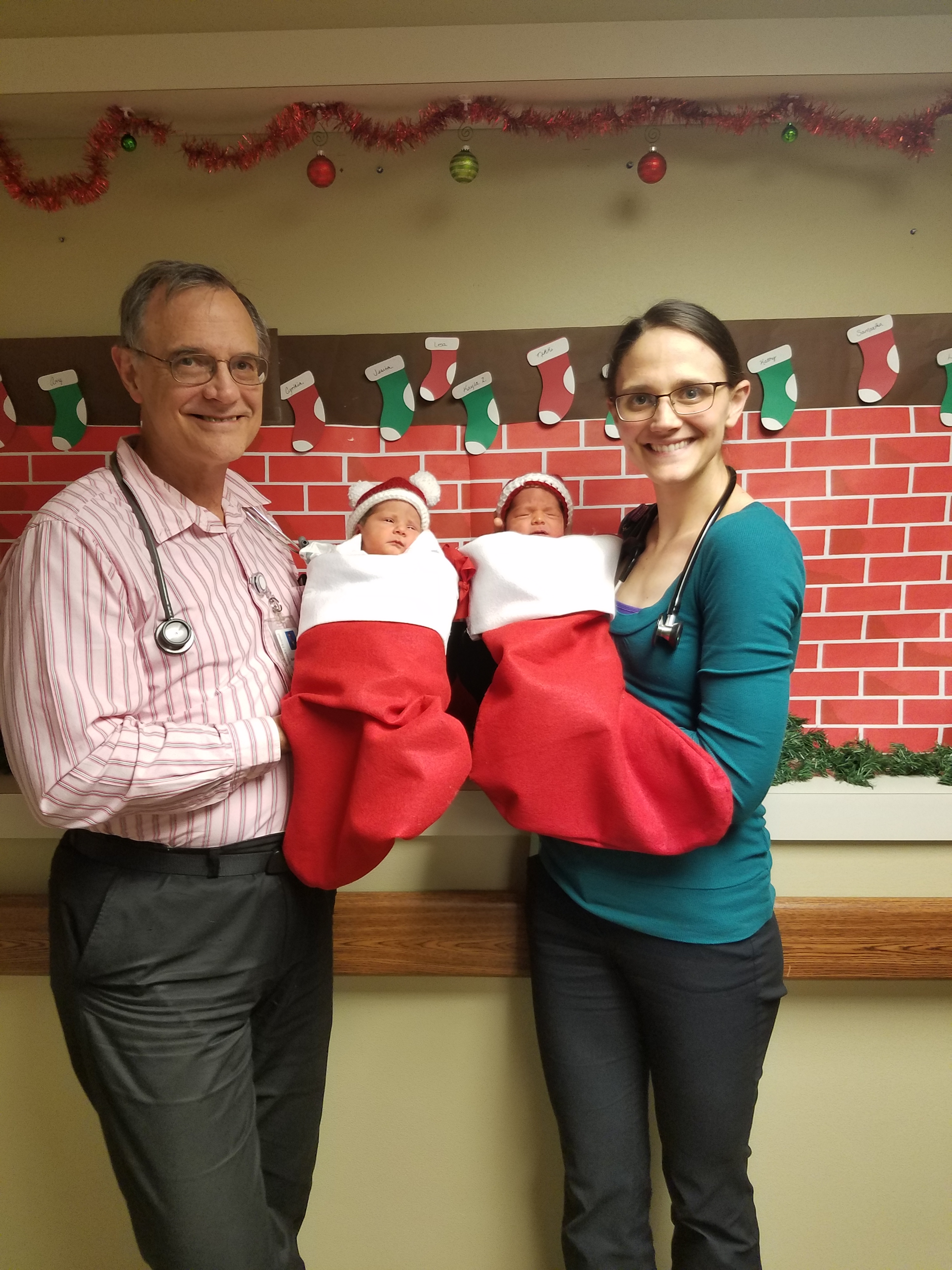 Dr. Ahrendsen and his daughter, Dr. McLoughlin, holding twins