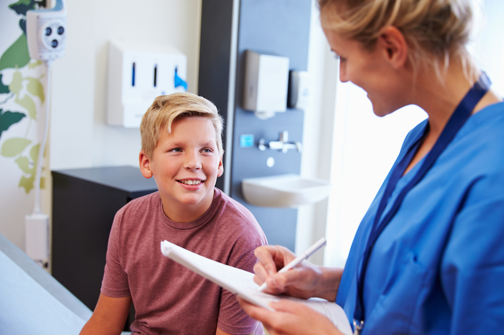 Teen boy at doctor's office talking with nurse