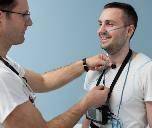 A clinician fits a patient with a monitoring device at Iowa Specialty Hospital before a sleep study.